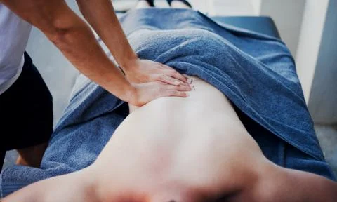 Back massage with hands compressing lower back Stock Photos