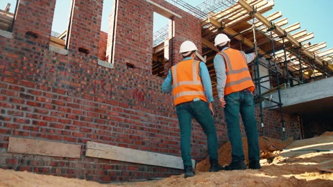 Back, men and talk with engineer at construction site for inspection, planning Stock Footage 336189578