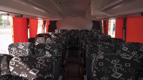 Back motion in the cabin of a large empty passenger bus between the rows of Stock Footage 244473834