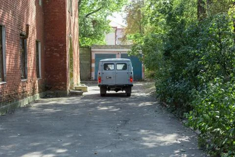 Back of old cargo van next to a brick building. Stock Photos