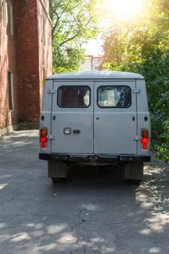 Back of old cargo van next to a brick building. Stock Photos