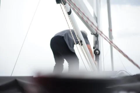Back of an older man working at the main mast Stock Photos