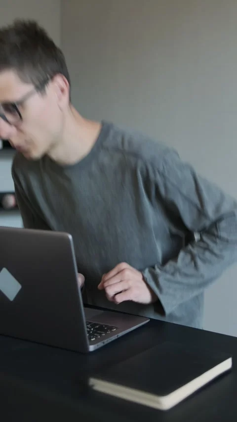  back in pain while standing up from desk after working on laptop.  Stock Footage 308241468