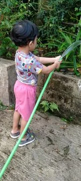 Back Perspective of Three Year Old Child Using Water Hose Stock Photos