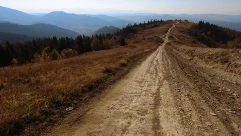 Back point of view: SUV with tourists on dirt road through rural road up to Stock Footage 122688191