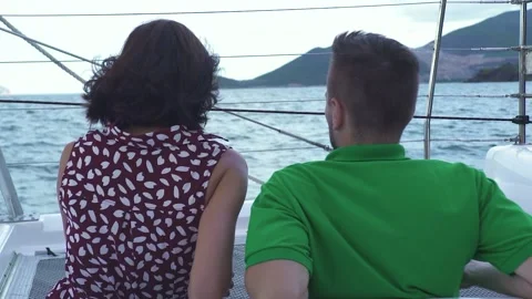 Back portrait of a couple sitting on the front deck of a yacht. Video stock 136429064