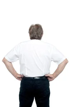 Back pose of a senior man standing with hands on his waist Stock Photos
