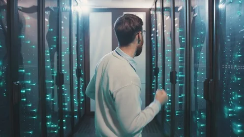 Back of positive IT specialist dancing of joy in modern server rack corridor Stock Footage 119231948
