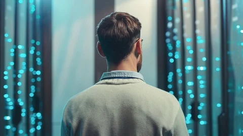 Back of professional IT engineer walking along server rack cabinets in computer Video stock 119233736
