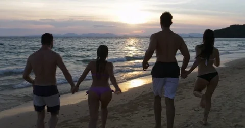 Back Rear View Of Cheerful Group Of People Running In Sea, Happy Friends Stock Footage
