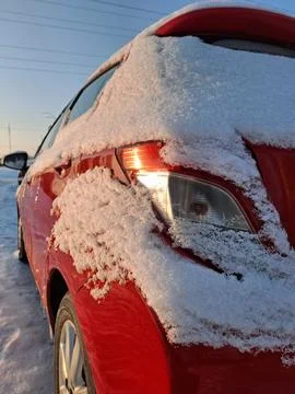 The back of the red car is blanketed in white snow Photos