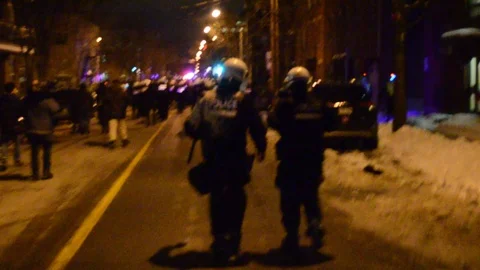 Back of riot policemen walk on the street Stock Footage