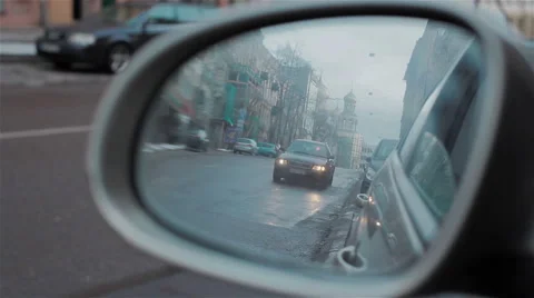 Back road reflected in car mirror, evening street with buildings and moving cars Stock Footage 46366851