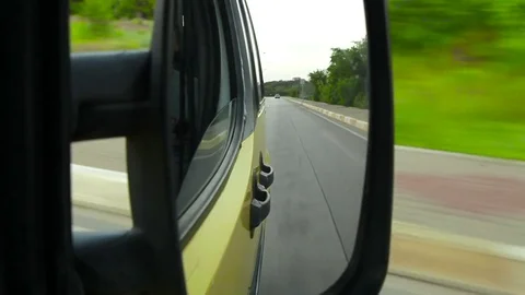 Back road reflected in car mirror, car driving fast on scenic landscape Stock Footage 74509245