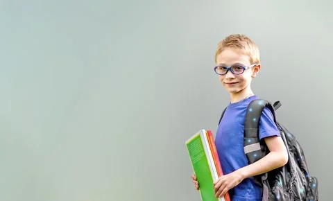 Back to school. An 8-year-old boy wearing glasses with school backpack and .. Foto stock