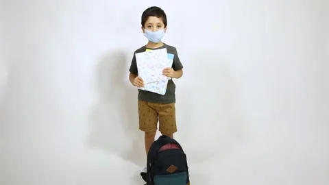 Back to school after Corona - 5 years old boy wearing face mask holding colored Stock Footage 132608521