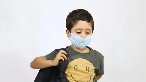Back to school after Corona - 5 years old boy wearing face stands up and put on Stock Footage 132608542
