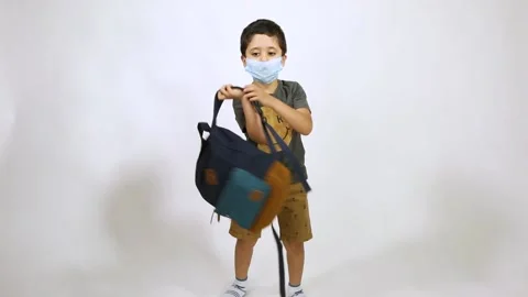 Back to school after Corona - 5 years old boy wearing face put on backbag waving Stock Footage 132608544