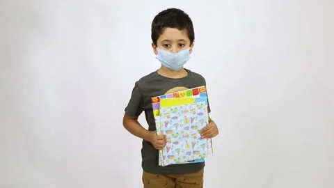 Back to school after Corona - 5 years old boy wearing face mask holding colored Stock Footage 132608545
