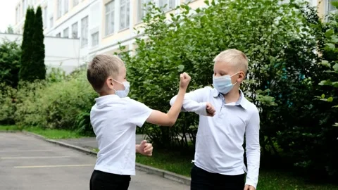 Back to school after quarantine. Cute boys Children say hello contactlessly Stock Footage 157008883