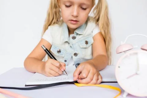 Back to school and happy time. Children holding pen and writting in notebook on Stock Photos