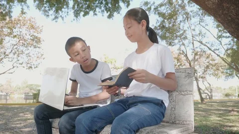 Back to School. asian girl using his laptop to learning online. and girl reading Stock Footage 127180490