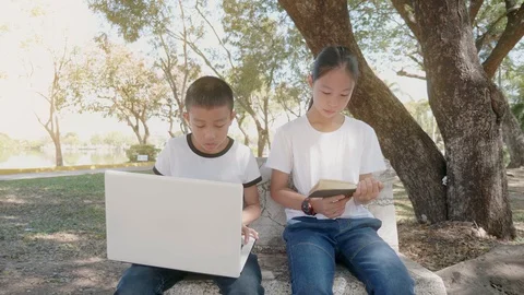 Back to School. asian girl using his laptop to learning online. and girl reading Stock Footage 127180732