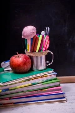 Back to school background with books and apple over blackboard. Stock Photos