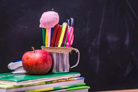 Back to school background with books and apple over blackboard. Stock Photos