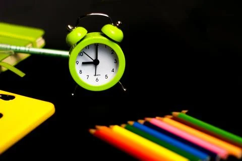 Back to school background with colored pencils and alarm clock. Concept with  Фото