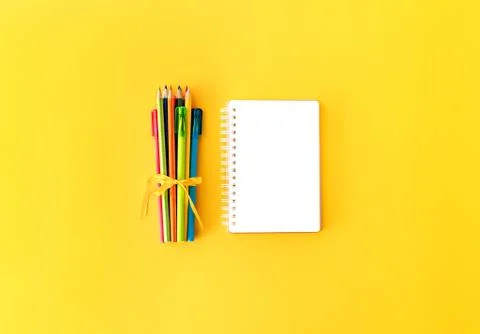 Back to school background with opened notepad and variety of colorful pens and Stock Photos
