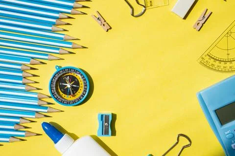 Back to school background with stationery objects on edges and empty yellow Stock Photos
