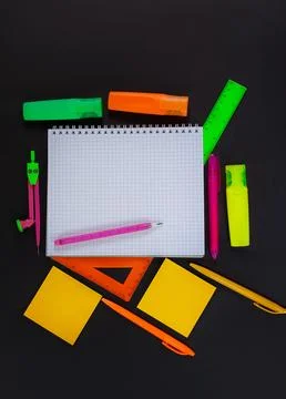 Back to school. On black table lies notebook checkered with pencil for text Stock Photos