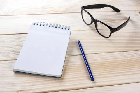 Back to school. Blank note pad, notebook with pen and glasses Stock Photos