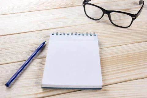 Back to school. Blank note pad, notebook with pen and glasses Stock Photos