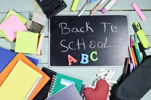 Back to School Chalkboard With ABC Letters and Colorful School Supplies on Woode Stock Photos