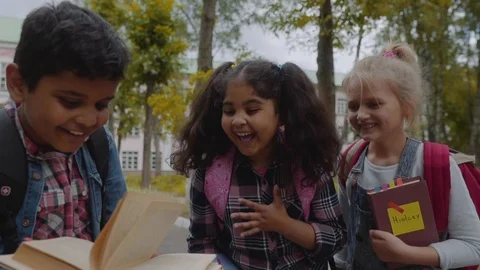 Back to school. Close up Three Friends With Backpacks huging and laughing in Vídeos de archivo 112669524