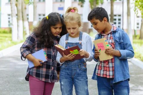 Back to school. Close up Three Friends With Backpacks huging and laughing in Stock Photos