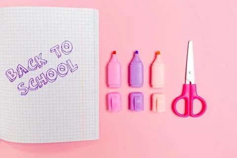 Back to school. Composition with opened copybook, markers and scissors on pin Stock Photos