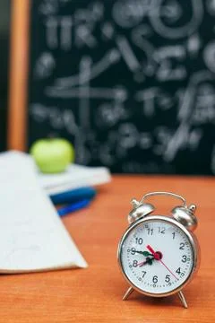 Back to school concept, alarm clock on school board background, university Stock Photos
