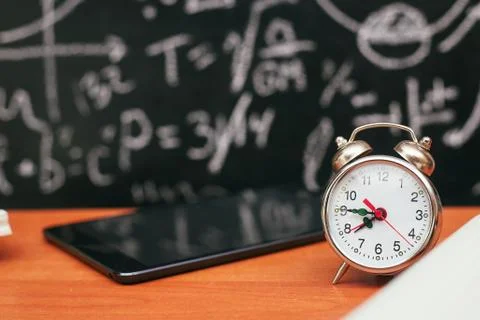 Back to school concept, alarm clock on school board background, university Stock Photos