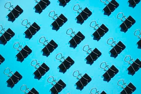 Back to school concept. Binder paper clips pattern on blue background Stock Photos
