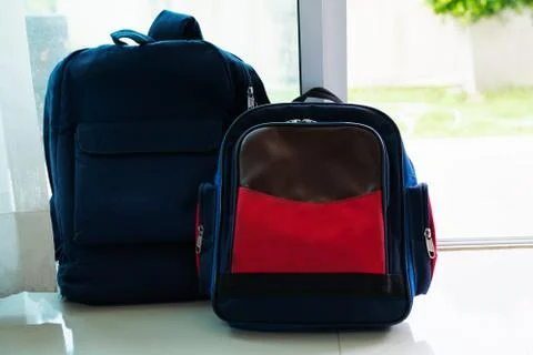 Back to school concept. Blue  backpack lean on the glass door for two kids Stock Photos