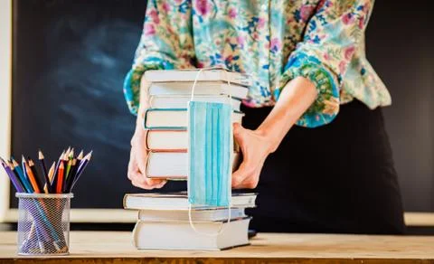 Back to school concept during covid - pile of books and medical mask Stock Photos