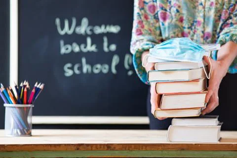 Back to school concept during covid - pile of books and medical mask Stock Photos