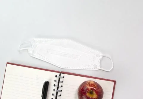 Back to school concept with education materials, face mask, note book, apple, Stock Photos