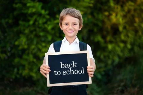 Back to school concept. Elementary school student boy holding blackboard Stock Photos