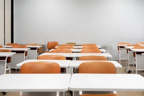 A back to school concept, empty classroom with white tables and chairs Stock Photos