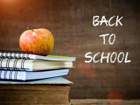 Back to school concept. Retro style of apple on stacks of books on  wooden ta Stock Photos