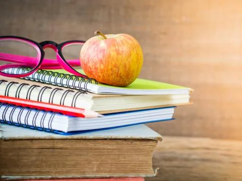 Back to school concept. Retro style of apple on stacks of books with pink gla Stock Photos